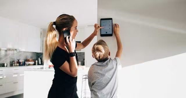 People reviewing a wall mounted security control panel